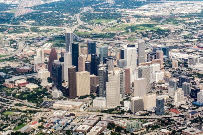 A view of Houston's sprawling landscape, showing a mix of green space and dense urban development.