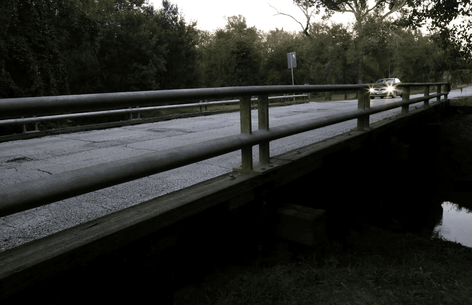 A dark, tree-lined road at night, representing Patterson Road.